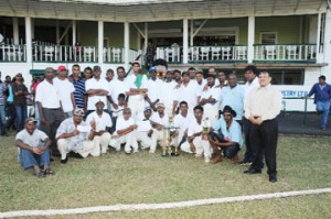 The victorious Lusignan Cricket Club (LCC) ‘A’ team and their supporters strike a pose with president of the Demerara Cricket Board and acting president of the Guyana Cricket Board Bissoondial Singh (right). (Clairmonte Marcus photograph)  