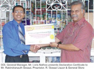 DDL General Manager Loris Nathoo (left) presents the Declaration Certificate to Rabindranauth Gossai, proprietor of R Gossai Liquor and General Store.  