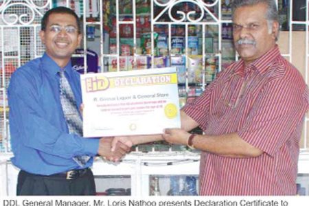 DDL General Manager Loris Nathoo (left) presents the Declaration Certificate to Rabindranauth Gossai, proprietor of R Gossai Liquor and General Store.  