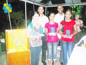 Rotary Club of Stabroek Peace Poster winners Serena Ming, Divya Lall and Zimeena Rasheed display their plaques at a ceremony held to honour them while Club members look on.