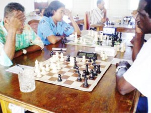 Taffin Khan (centre), during his game with National Champion Kriskal Persaud at the Topco Juice Mashramani chess tournament. Taffin is the current National Junior Champion but is playing among the seniors now. In this his first tournament at the higher level, he defeated Kriskal with ease and confidence.