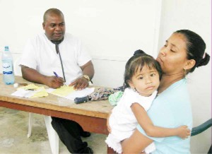 Dr Alexander Sinclair attending to a young patient during the medical outreach.