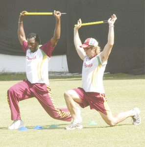  West Indies skipper Christopher Gayle (left) shows no signs of discomfort when he was caught doing some light stretches with team physiotherapist CJ Clark.  