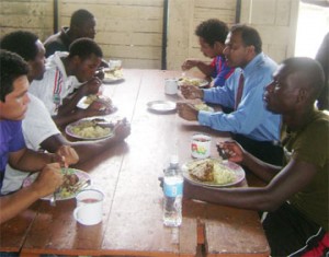 Minister of Sports Dr. Frank Anthony having lunch with the Alpha United football Club yesterday at Camp Soweyo (Rawle Toney photo)