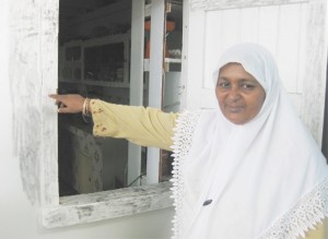 Ameena pointing to fingerprints on the window that the men broke to enter the building. 