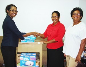 In photo, Prema Ramanah-Roopnarine (left) hands over the computer to Vilma Da Silva 