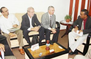 Minister of Agriculture, Robert Persaud (right), and a Brazilian rice team discussing possible cultivation of a new rice type in Region Nine. (Ministry of Agriculture photo) 