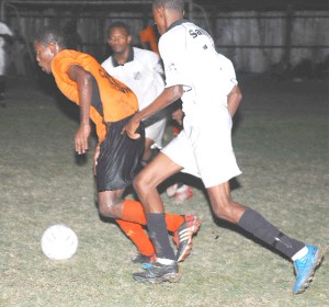Sunburst Camptown’s Telson McKinnon (in orange) bursts through two Santos defenders in the quarterfinal match of the GFA Banks Premium Beer Competition on Wednesday at the Tucville playfield. (Clairmonte Marcus photo) 
