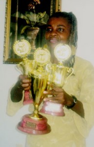 Pearl Lewis holding her Guyana Annual first, second and third prizes 