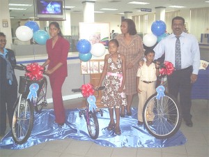 In photo, the young winners proudly pose with their bicycles with GBTI representatives in the background. From left to right the winners are Yasmin Raza, Sarah Sanmoogan and Mahadev Basdeo.  