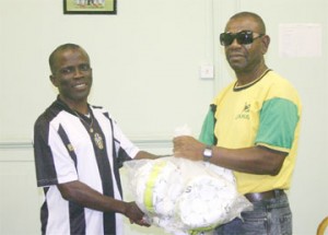  Ministry of Sport football coach Dennis ‘Chow’ Hunte hands over a number of footballs to Coordinator for the BV inter-block football competition Joseph Wilson. (Photo by Orlando Charles) 