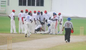 Flashback: Concerned players from both Demerara and Berbice pay keen attention as the physiotherapist attends to the injured Ranole Bourne who had suffered a broken thigh bone.