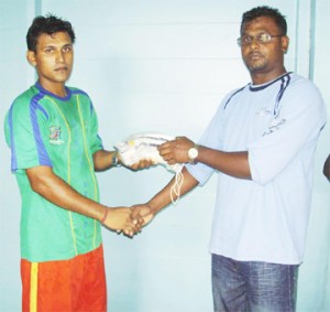 Port Mourant Cricket Club President Devendra Khallendra (right) handing over some of the gear