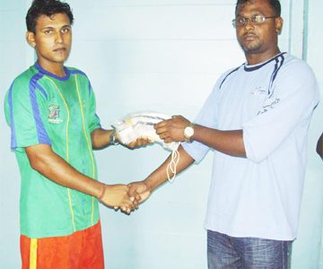 Port Mourant Cricket Club President Devendra Khallendra (right) handing over some of the gear