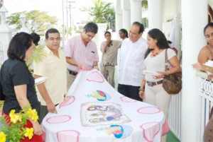 This tablecloth was one of the more elaborate pieces on exhibition. Ambassador Dario Morandy, second from right, looks on.   