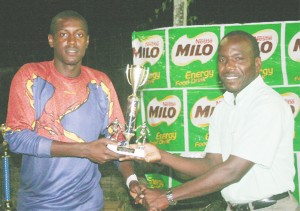Secretary of the George-town Football Association, Marlan Cole (right) presents the Best Goal-keeper of the Tourna-ment trophy to Richie Richards. (Orlando Charles photo) 