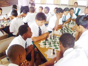 The Guyana Chess Federation (GCF) has intensified its training programme in schools for the Easter holidays. GCF Tournament Director Irshad Mohamed has been moving around quite a bit recently. Last week, he worked at the Bishops’ High school giving chess instruction to the students. Some fifty students of the school have benefited from his expertise and experience. Mohamed teaches chess every Saturday after lunch at the Oasis Cafe in Carmichael Street, and has held a number of tournaments at that venue. Kids can learn to play the game at the Oasis any Saturday between 1 pm and 5 pm. In the photo above, Bishops’ students engage in some friendly encounters during one of Mohamed’s training sessions. 
