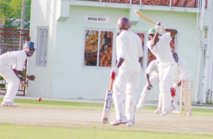 Watched by non- striker and teammate Delbert Hicks (left), national middle order batsman Royston Crandon executes a drive back along the pitch during his unbeaten 65 against Barbados yesterday. (An Orlando Charles photograph)  
