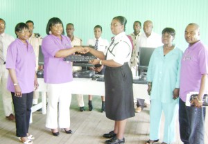 Bonita Wolfe Woodhouse (second from left), a member of the New York Chapter of the Association of Ex-Presidential Guards and Immigration Officers (APGI), presents a computer to Deputy Chief Immigration Officer of the Immigration Department, Superintendent Carol Lewis-Primo while other members of APGI, immigration officers and presidential guards look on.   