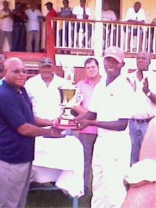 Berbice skipper Anthony Bramble (right) receives the winner’s trophy from Edward Persico Company Secretary/Human Resources Manager of GTM.  