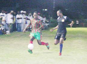 Guyana Defence Force’s Marlon Benjamin (left) attempts to go around Alpha United’s Howard Lowe during their semi final clash in the Digicel/Mackeson Stout Sweet 16 semi final clash on Tuesday night. (Orlando Charles photograph)  