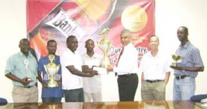 Secretary of the GFA Marlon Cole (3rd L) accepts the Banks Beer First Division Trophy and cheque on behalf of champions BK International Western Tigers from Banks DIH’s Sales and Marketing Executive Carlton Joao.   