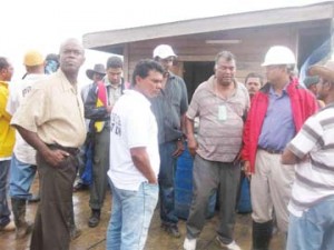 Minister of Agriculture Robert Persaud (second from right) and team including residents of Abary Creek standing on the pontoon as the dredging was in progress.
