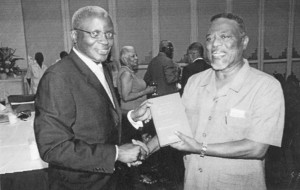 Dr Claude Denbow presents a copy of his book to Prime Minister Samuel Hinds. 
