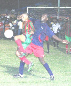 GDF’s Stellon David (airborne) battles for control with a Cougars defender during the final of the Mackeson stout/Digicel Sweet 16 final on Sunday night at the Plaisance Community Centre ground (Photo by Orlando Charles) 