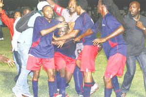 Fans and teammates of Cougars Football Club of Berbice mob Horace Roach after he scored the opening goal against Guyana Defence Force in the final of the Digicel/Mackeson Stout Sweet 16 final on Sunday night. (Photo by Orlando Charles)  