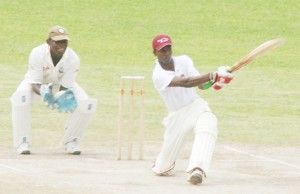 Watched by wicketkeeper Anthony Bramble, centurion Herrell Greene gets down on one knee to play a delivery through the leg side during his 145 yesterday. (Orlando Charles photograph)  