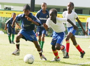 Opening Day Action! Sunburst Camptown’s Jason Williams (2nd R) goes on the attack against Thomas United in the Courts Pee Wee Under-11 Competition at the Banks DIH Ground, Thirst Park yesterday. (Orlando Charles Photo) See story on page 31 