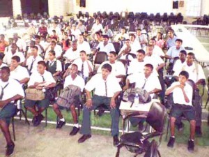 During the recent whirlwind visit to Guyana by German Grandmaster Rainer Buhmann, a number of secondary school students from various schools across the country gathered in the Queen’s College auditorium. They attended a chess lecture delivered by the grandmaster and some participated in an open simultaneous exhibition which he hosted. In the photograph, students listen attentively to Grandmaster Buhmann during his lecture. 