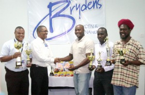 Marketing Coordinator of Bryden and Fernandes Inc. Mark Kendall hands over the sponsorship cheque to Vice President of the GFA Jason Benjamin while Marketing Representative Rawle Davson (L), and Secretary and Second VP of the GFA Marlan Cole (2nd R) and Sampson Gilbert (right) look on. (Orlando Charles photo) 