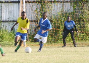 An East Coast (left) and a Georgetown (right) player battle for possession of the ball in yesterday’s encounter which Georgetown won 4 – 0 at the Tucville Playfield. (Orlando Charles Photo) 