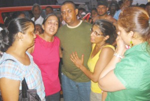 Lynette Balram and another survivor, second left and right respectively being consoled by relatives  