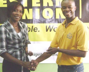 Western Union’s marketing manager, Natheeah King (left) hands over the sponsorship cheque to Carwyn Holland yesterday.
