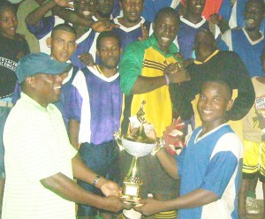Ministry of Sports Parliamentary Secretary Steve Ninvalle hands over the cash and winner’s trophy to Airstrip captain Naquacy Leitch. 