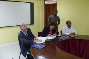 Minister of Foreign Affairs, Carolyn Rodrigues- Birkett (center) and Regional Representative of IOM (left) signs the agreement to implement immigration programmes in Guyana. Also in the photo is Minister of Home Affairs Clement Rohee