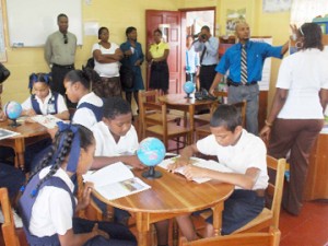 Students making use of Reading Room after it was officially opened. Anthony Hunte - Community Involvement Specialist in back taking photo