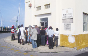 A section of the large crowd which had lined up outside the Barbados Immigration Department in Bridgetown on Tuesday. Many were Guyanese who said they were there mainly to check on the status of work permits. (Heppilena Ferguson photo)