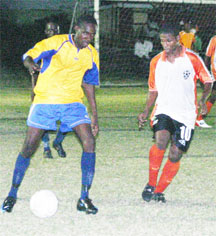 In this Orlando Charles photo BK Int’l Western Tigers’ Devon Millington is marked closely by a defender in the first half of their encounter against Sunburst Camptown.