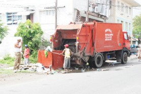 Puran Brothers’ workers removing commercial waste in the city yesterday. (Photo by Jules Gibson)