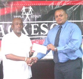  Stanford Solomon (left) collects his sponsorship cheque from Ansa McAl’s Marketing Director Troy Cadogan. (Orlando Charles photo)   