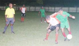 GDF’s Warren Gilkes (R) and Camptown Telston McKinnon (centre) battle for possession under the close watch of referee Otis James at the Tucville Playfield. (Orlando Charles Photo)  