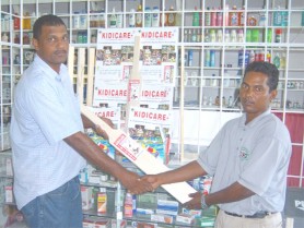 Essequibo’s Darshan Persaud (right) receives the softball equipment from GSL Organizing Secretary Leonard Harprashad (left). 