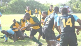 Guyana’s Jamal Yarde (with ball) goes through the Bahamian defense to score a try for his team on Wednesday. (NAWIRA photo) 