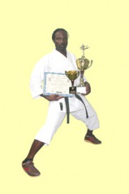 Fourth  Dan Black Belt Troy Bobb in a martial arts stance with trophies won at the 2009 Nationals Tournament held in Albuquerque, New Mexico, USA.