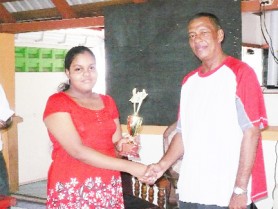  President of the Guyana Chess Federation Errol Tiwari presents Miranda with her trophy at the conclusion of the tournament. 