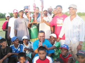 In photo, Raymond Ramdatt (stooping at centre) and a member, Krishna Seelall (at right) pose with young residents and the winners of the cricket competition.